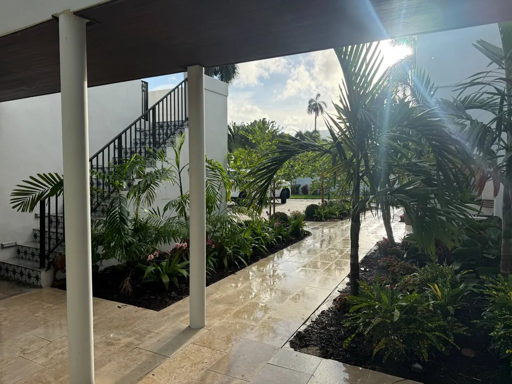 Covered loggia and landscaped path with tropical planting